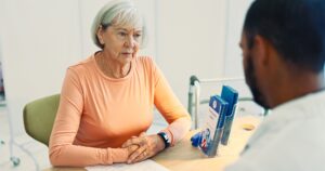 Doctor, consultation and senior woman with healthcare, stress and cancer news of patient. Consultin