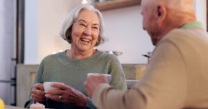 Funny, retirement and a senior couple drinking tea in the dining room of their home together in the